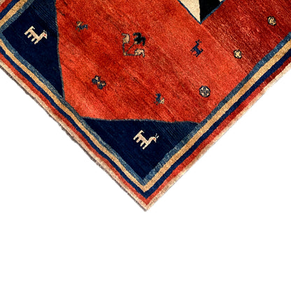 Rug corner with a red field and blue border, small animal motifs