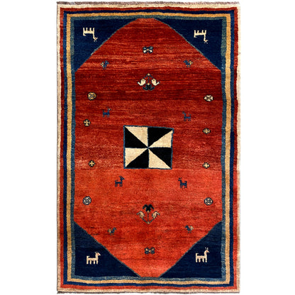 Gabbeh rug with red center, blue border, and white-and-black octagonal motif