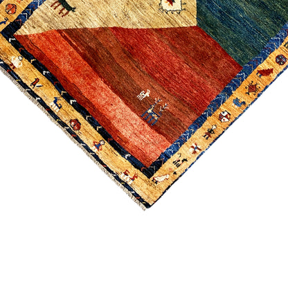 Gabbeh carpet detail: red and green area with a blue border and ornaments