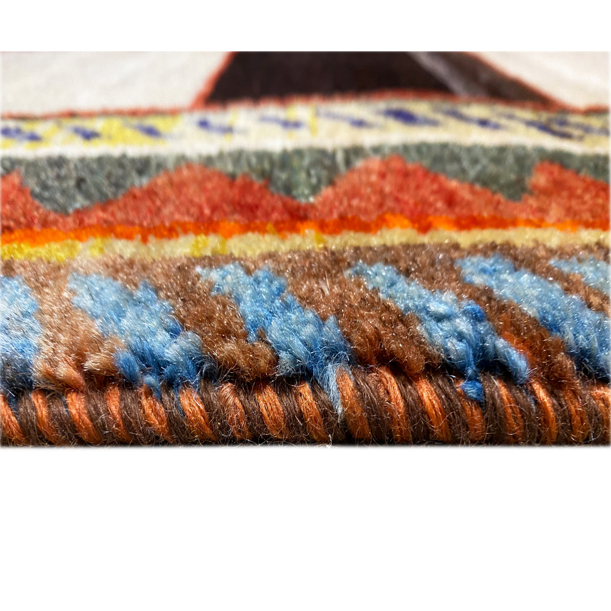 Gabbeh rug close-up of the pile: multicolored threads with a border trim