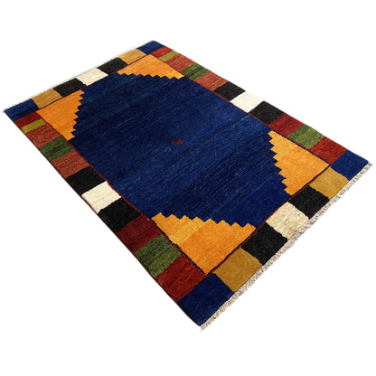 Rug with a blue center, yellow-orange zigzag borders, and colorful checkered elements.
