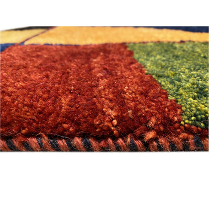 Carpet pile detail with a reddish-brown area and green accent next to an orange-yellow area.