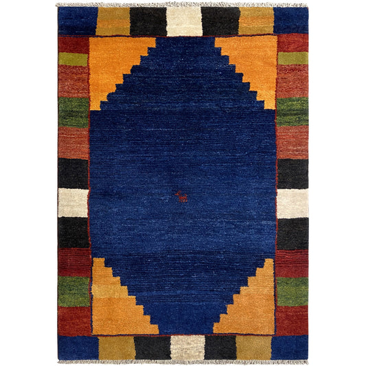 Rectangular rug with a blue medallion and multicolored checkered border.
