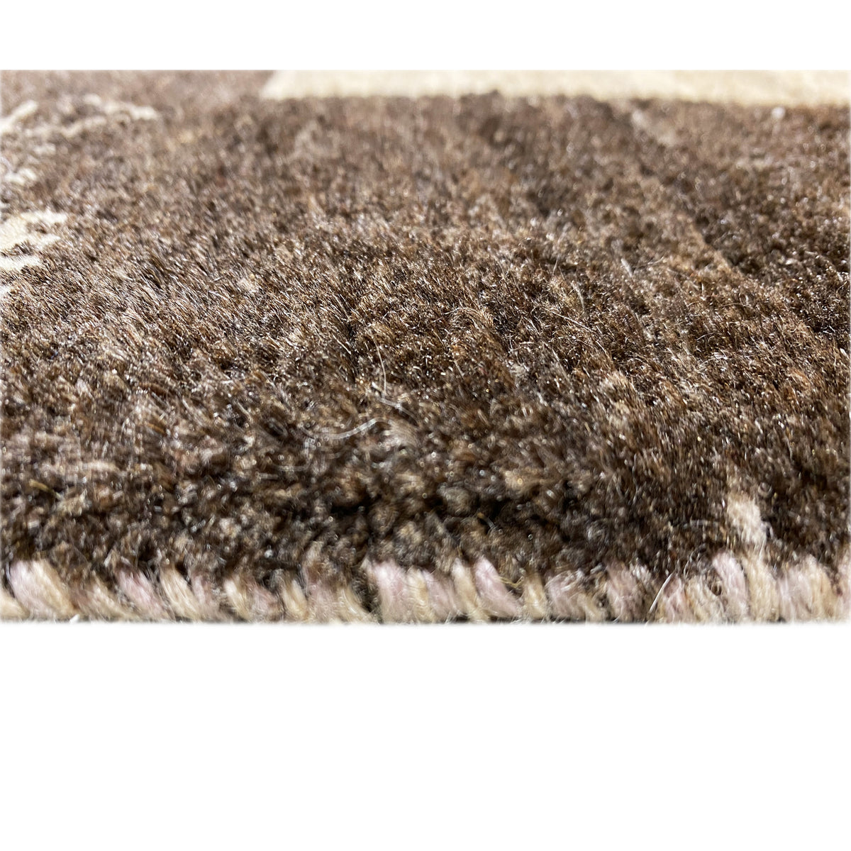 Close-up of carpet pile, dense beige and brown-black pile with fine patterning