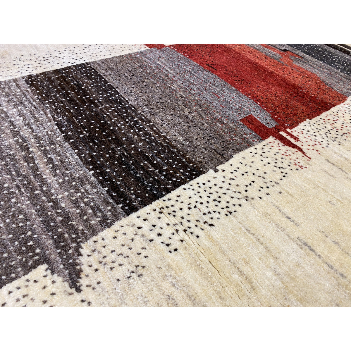 Gabbeh rug close-up: woven texture with black, gray, and red color blocks