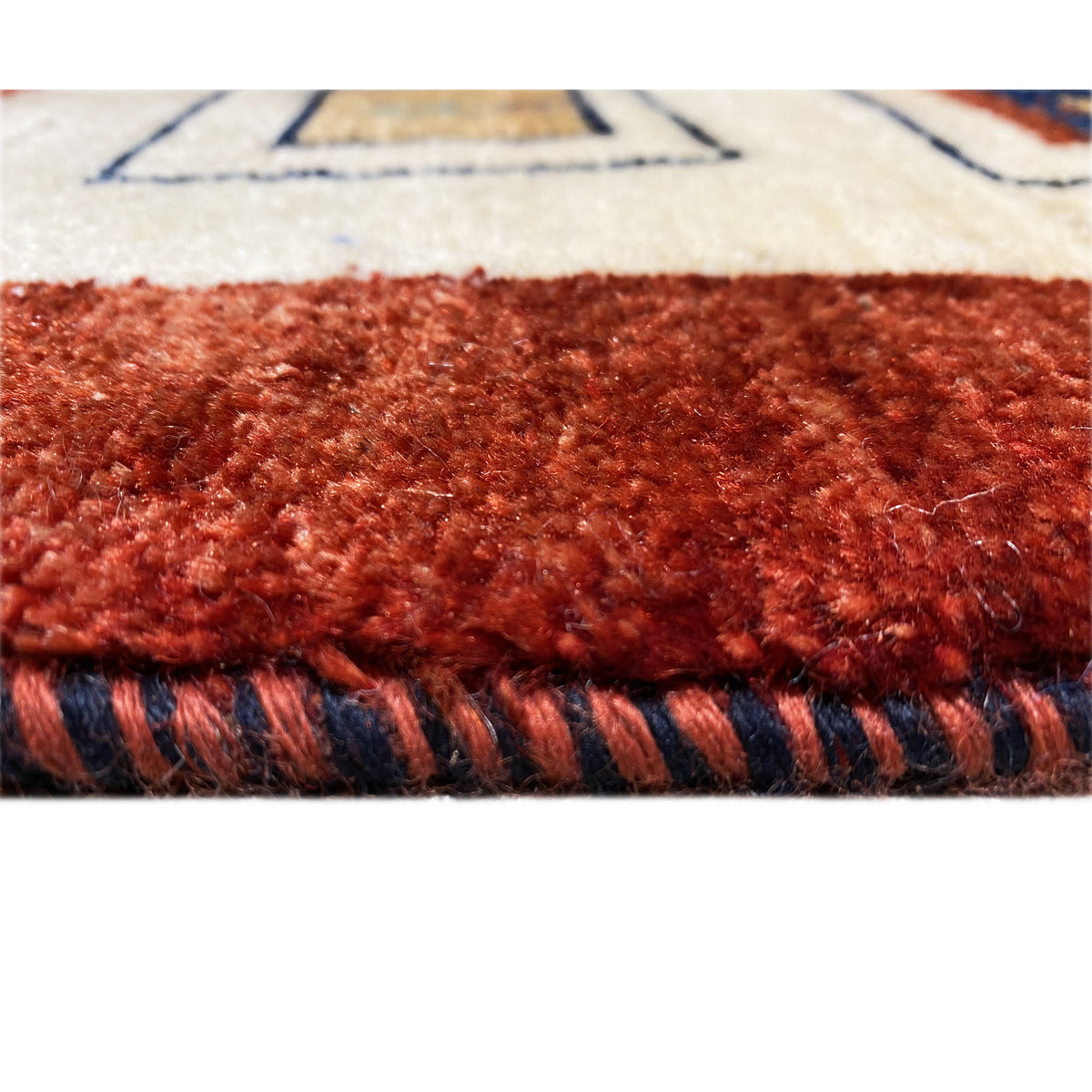 Carpet detail: reddish-brown pile with visible edging and a multicolored border band