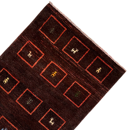 Brown Gabbeh rug corner with red framed squares and woven-in symbolic motifs