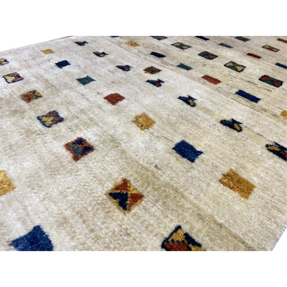 Close-up of the Gabbeh rug: beige pile with small multicolored motifs