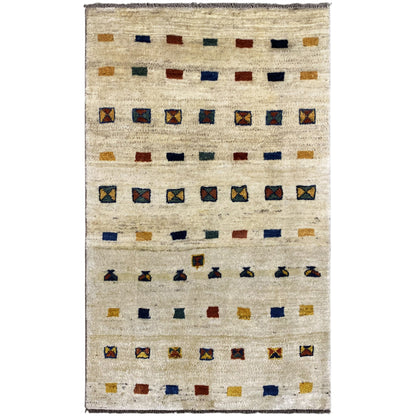 Gabbeh rug with a beige background and geometric quadrilateral patterns in blue, red, and ochre