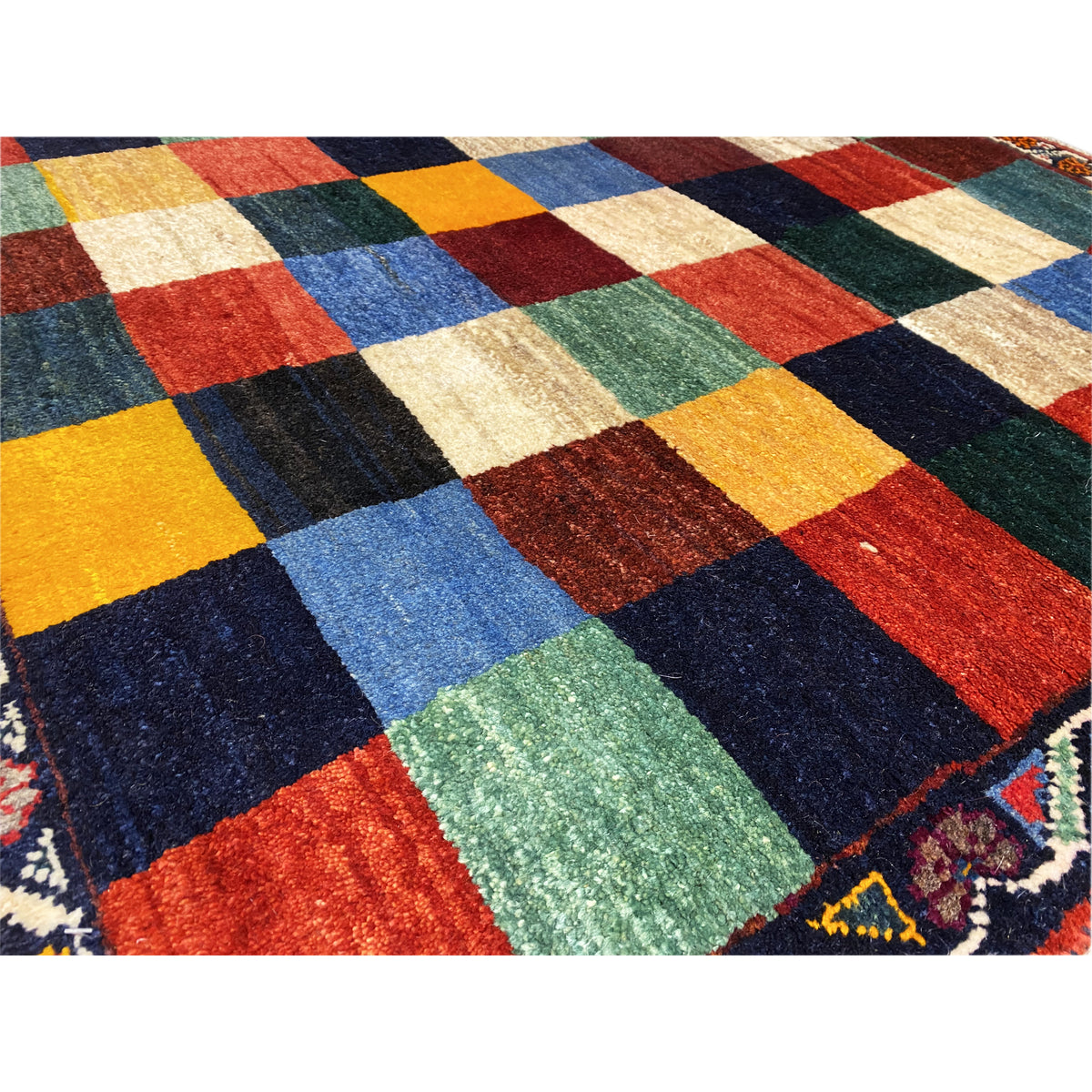 Gabbeh rug detail, bold checked fields in yellow, blue, red, green, and cream