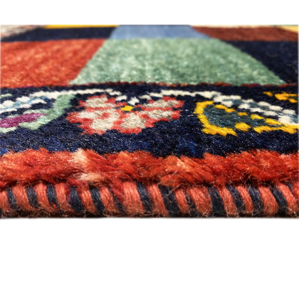 Gabbeh rug detail, pile and fringe at the edge with multicolored checks