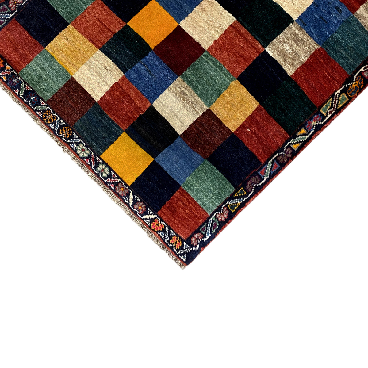 Gabbeh rug corner with fringes, multicolored checkered panels and border frame