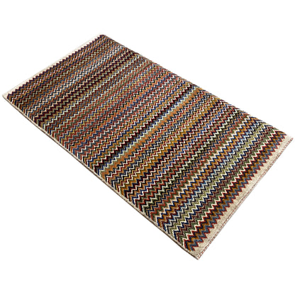 Gabbeh rug 130x75 cm, diagonal view: zigzag stripes in brown, blue, and beige.