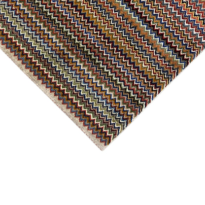 Gabbeh rug 130x75 cm Detail: Zigzag pattern in blue, brown, and beige with a bordered edge.