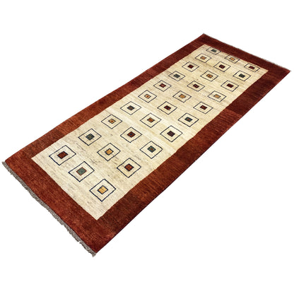 Runner rug with a brown border, cream-colored field, and square ornaments