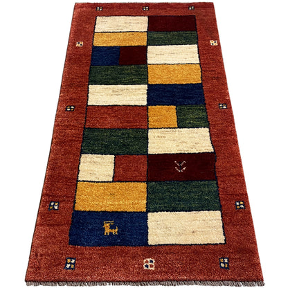 Rectangular Gabbeh runner with patchwork blocks in red, cream, blue, green, and gold