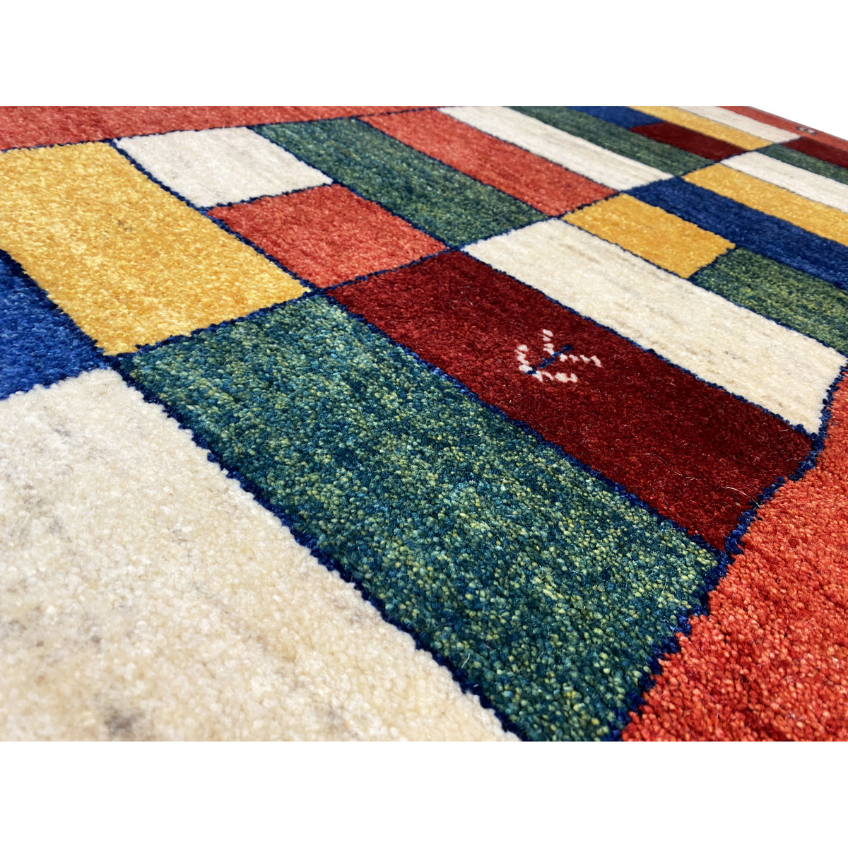 Close-up: Gabbeh runner with colorful patchwork sections in red, blue, green, cream, and gold