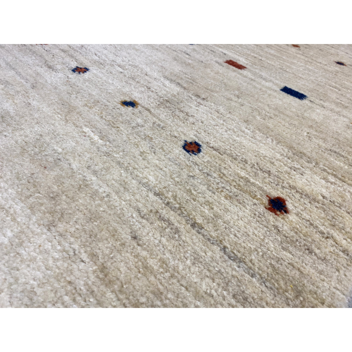 Close-up of Gabbeh runner: light beige surface with small multicolored dot motifs