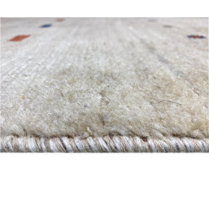 Close-up of a Gabbeh runner, light beige woven texture with fringes along the bottom edge