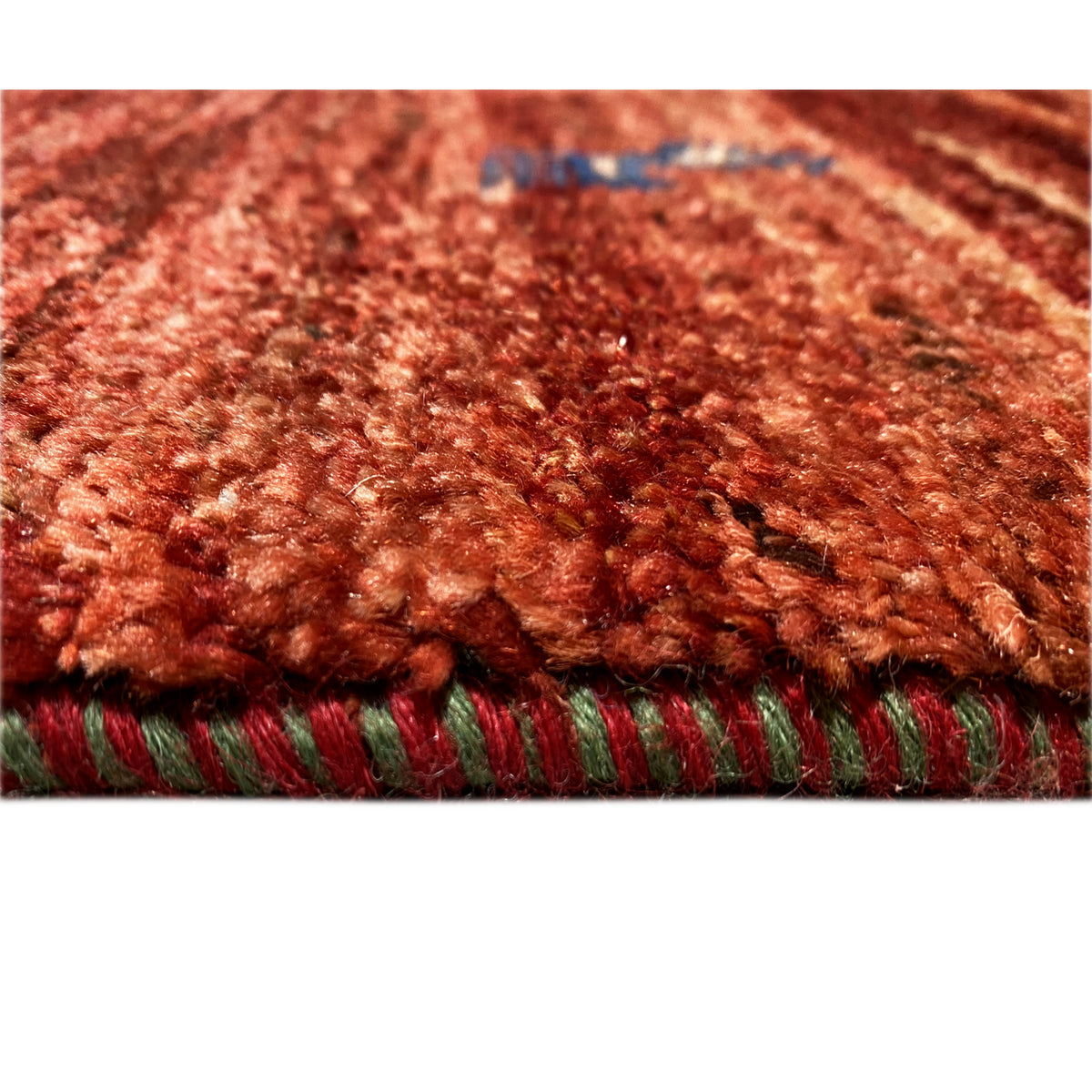 Gabbeh rug 140x93 cm detail view with pile and multicolored braid along the edge