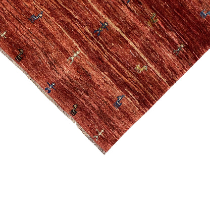 Gabbeh rug 140x93 cm close-up: reddish-brown field with colorful ornament and fringe