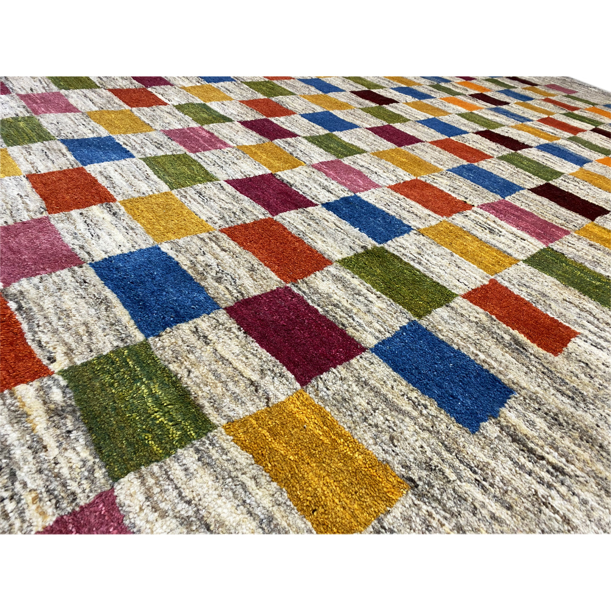 Close-up of a Gabbeh rug: colorful cube-like bands on a beige, textured pile