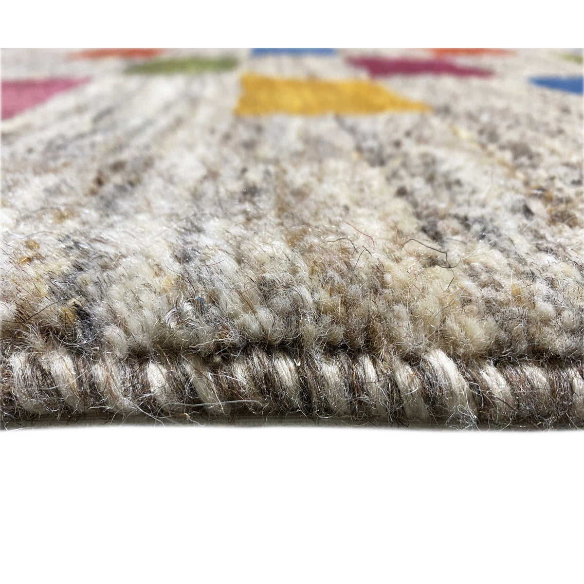 Gabbeh rug detail of the pile texture: soft, mottled beige rug with dye stains