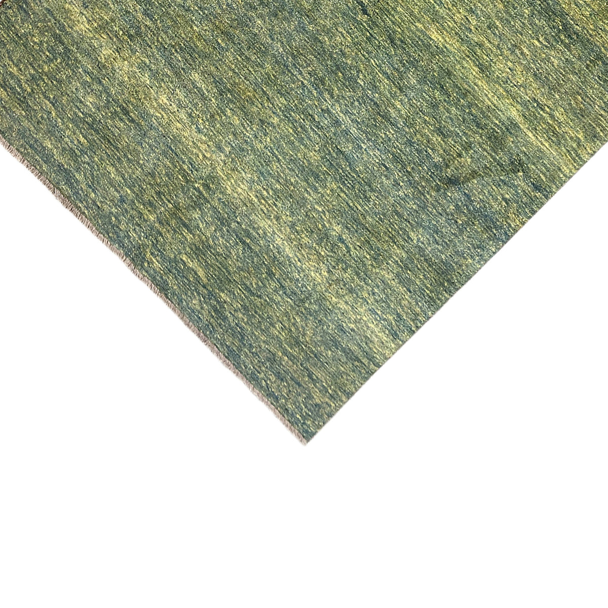 Green gabbeh rug corner with mottled texture and light brown pile edge