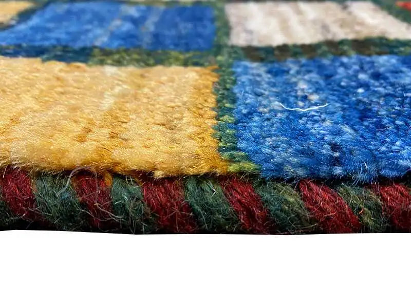 Close-up of a rug: multicolored selvedge and pile fibers in blue, green, and red