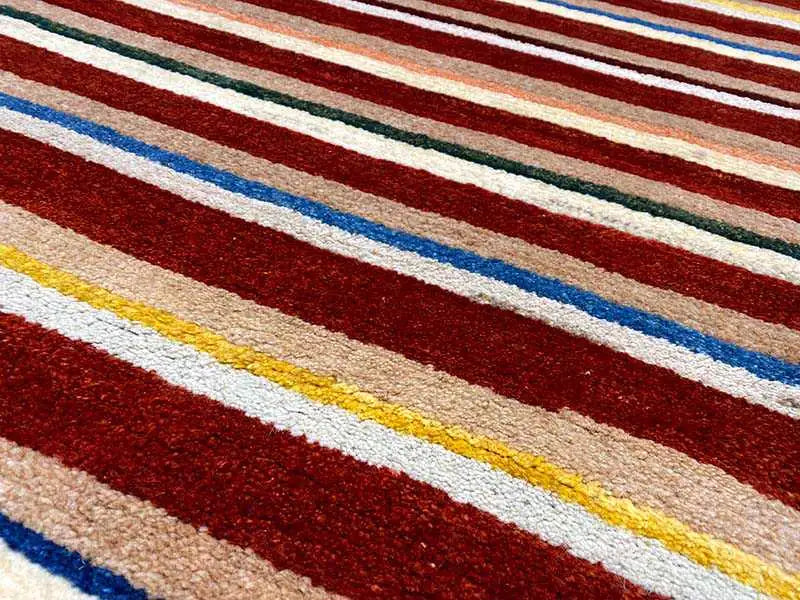 Rug with wide stripes in red, blue, beige, and yellow, fine woven texture
