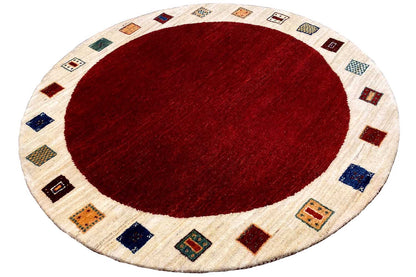 Round Gabbeh rug, red circular pattern in the center, cream-colored border with squares