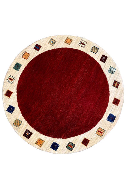 Round Gabbeh rug with a red central field and multicolored patterned border, 148×148 cm