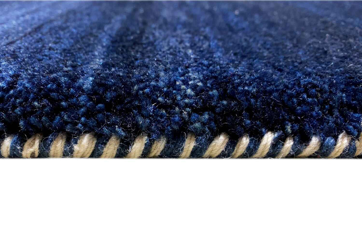 Blue Gabbeh rug: close-up of the edge with dark fringes
