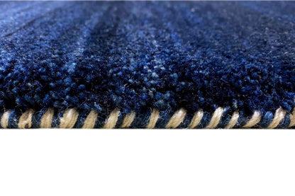 Blue Gabbeh rug: close-up of the edge with dark fringes