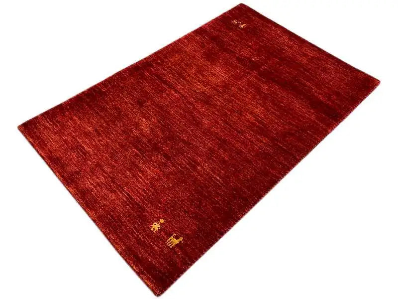 Red Gabbeh rug with a fine woven pattern and small yellow medallions, angled