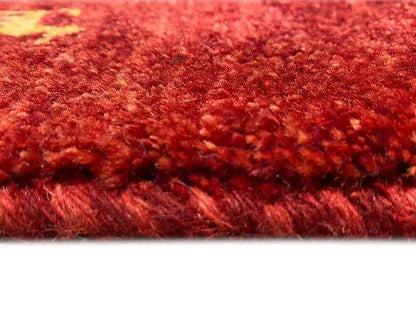 Close-up: Red Gabbeh rug with a dense pile and an even weave pattern