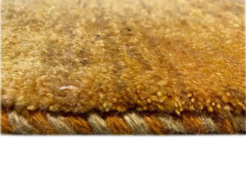 Gabbeh rug pile in ochre, close-up of fibers and weaving structure
