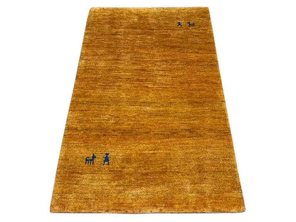 Gabbeh rug in golden brown, simple with small blue accents