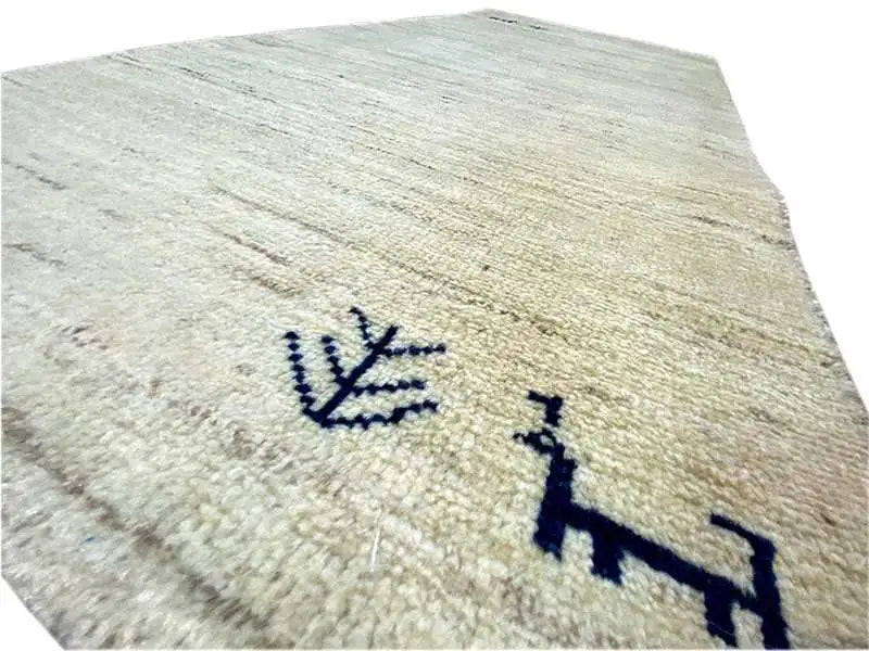 Close-up: Gabbeh rug, beige pile with a dark blue geometric pattern.