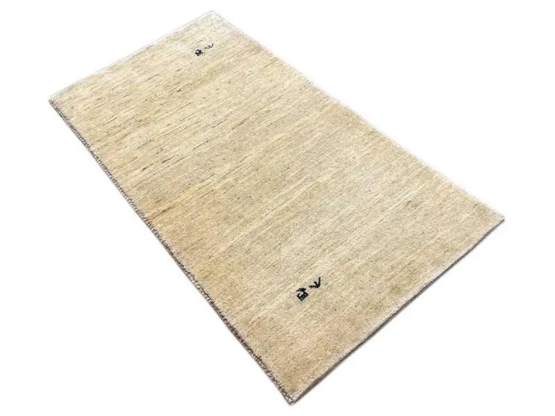 Gabbeh rug, beige, rectangular in angled view, fine woven texture, blue markings
