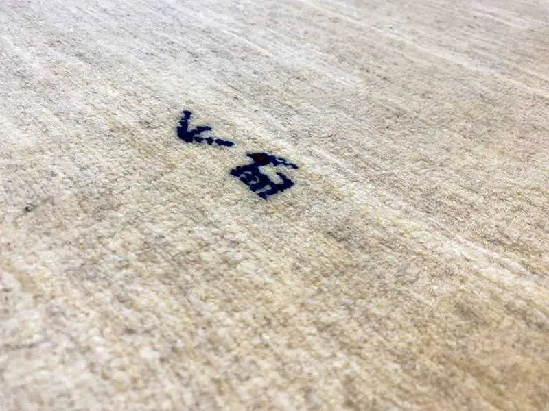 Gabbeh rug detail: beige pile with blue markings