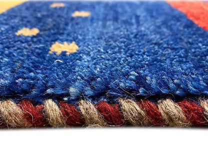 Close-up of a Gabbeh rug: blue pile with a red border and light accents