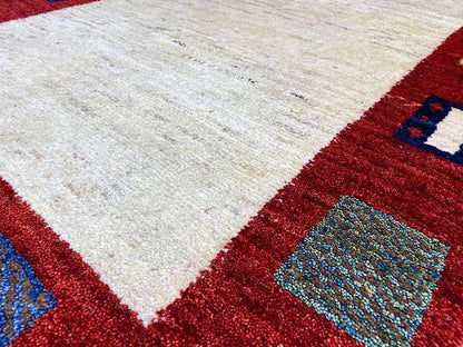 Gabbeh rug corner with a beige field and red border, detail of the border ornaments