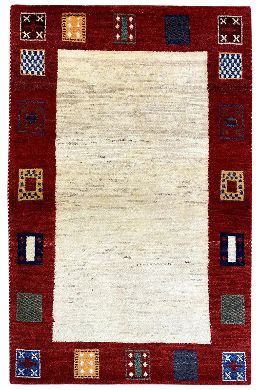 Gabbeh rug, red border with small patterned squares and a beige center piece