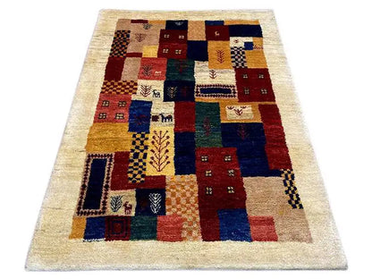 Gabbeh rug with patterned squares in blue, red, yellow, and green on a beige background