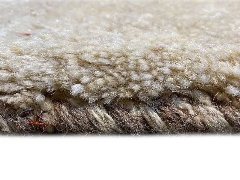 Close-up of a Gabbeh rug: dense pile with a soft, beige surface