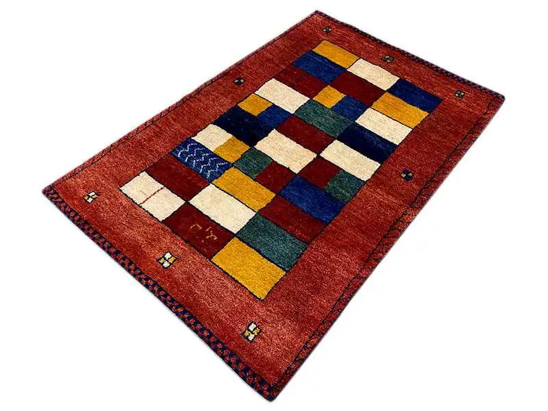 Gabbeh rug photographed diagonally: red rectangle with patchwork color squares