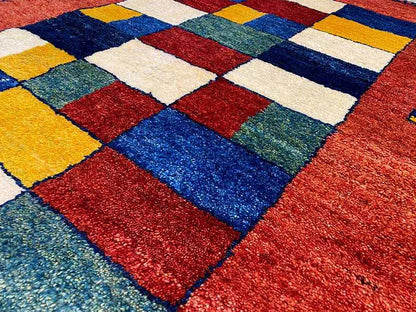 Gabbeh rug detail view: colorful patchwork square pattern in yellow, blue, green, red