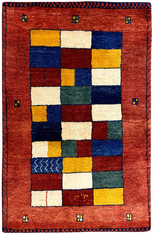 Gabbeh rug with a red border and central field featuring multicolored square patterns