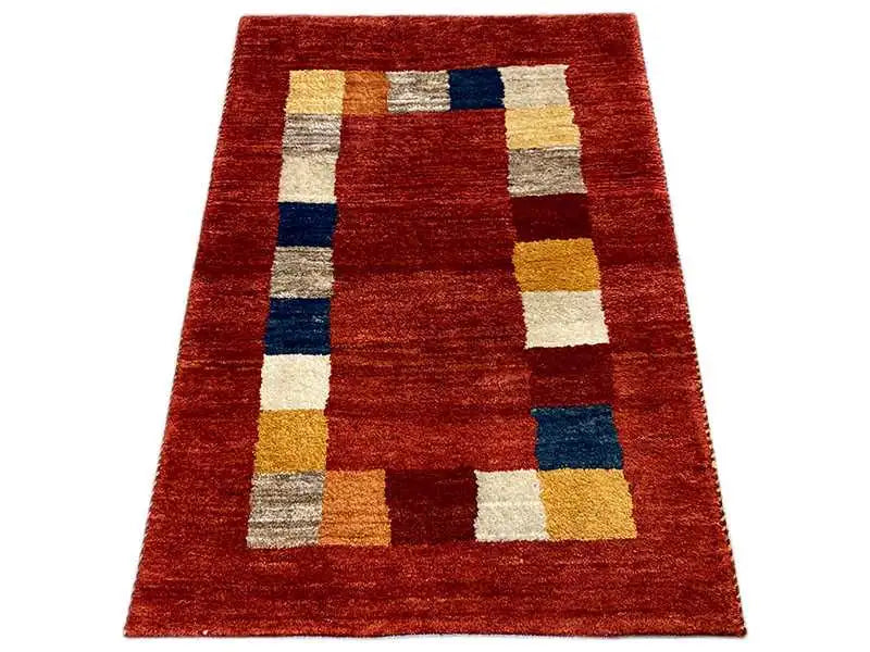 Gabbeh rug, rectangular: reddish-brown base pattern with multicolored square blocks.
